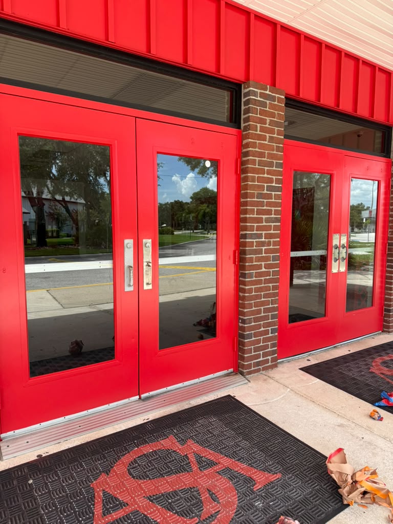 All Saints Academy freshly painted red entry doors