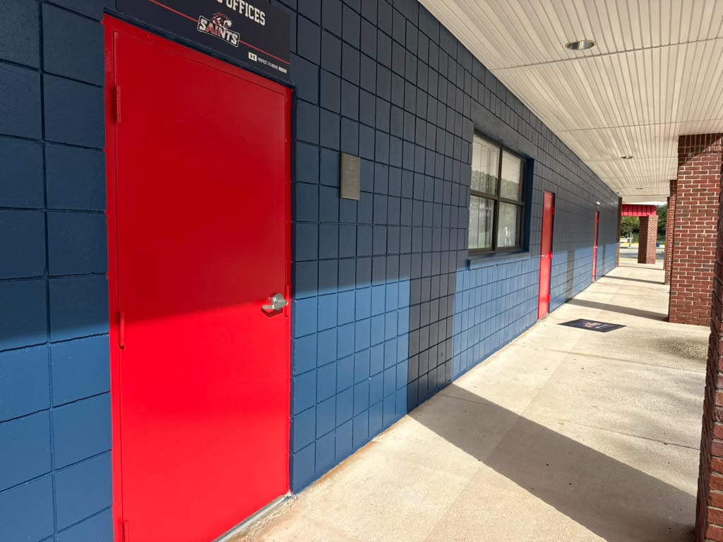 All Saints Academy blue exterior wall with red door